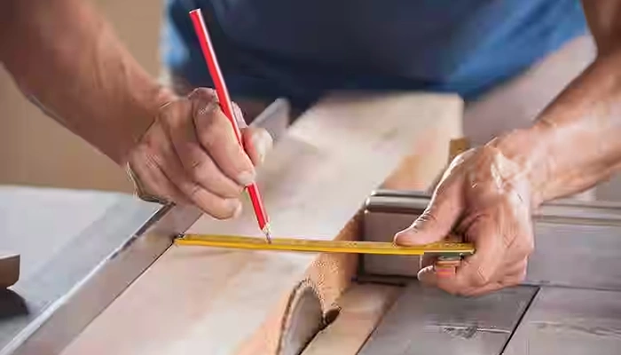Carpenter cutting timber planks to size for a custom carpentry and interior woodwork project